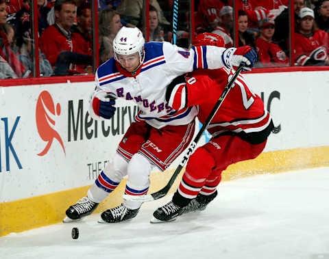 RALEIGH, NC – MARCH 31: Sebastian Aho #20 of the Carolina Hurricanes knocks Neal Pionk #44 of the New York Rangers off the puck during an NHL game on March 31, 2018 at PNC Arena in Raleigh, North Carolina. (Photo by Gregg Forwerck/NHLI via Getty Images)