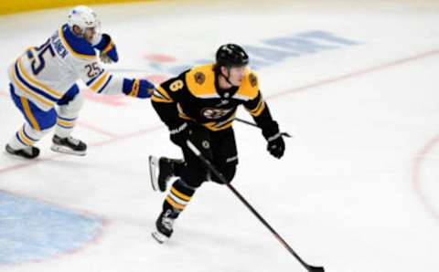 Apr 13, 2021; Boston, Massachusetts, USA; Boston Bruins defenseman Mike Reilly (6) skates with the puck in front of Buffalo Sabres center Arttu Ruotsalainen (25) during the first period at TD Garden. Mandatory Credit: Brian Fluharty-USA TODAY Sports