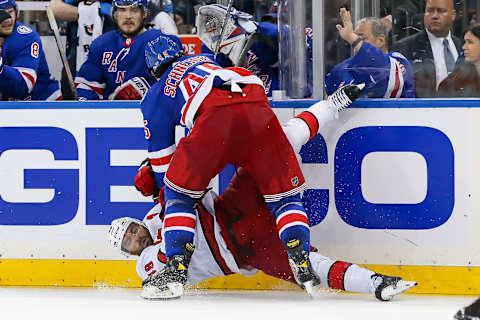 Apr 26, 2022; New York, New York, USA; New York Rangers defenseman Braden Schneider (45) puts a hit on Carolina Hurricanes left wing Jordan Martinook (48) during the third period at Madison Square Garden. Mandatory Credit: Tom Horak-USA TODAY Sports