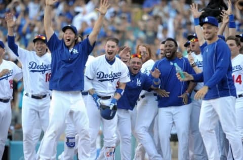 September 25, 2016; Los Angeles, CA, USA; Los Angeles Dodgers starting pitcher Kenta Maeda (18), starting pitcher Clayton Kershaw (22), catcher Yasmani Grandal (9) and catcher Carlos Ruiz (51) celebrate after shortstop Charlie Culberson (6) hits a walk off solo home run in the tenth inning against the Colorado Rockies at Dodger Stadium. With the victory the Dodgers clinch the National League West title. Mandatory Credit: Gary A. Vasquez-USA TODAY Sports