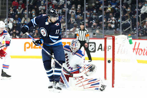 Mar 6, 2022; Winnipeg, Manitoba, CAN; New York Rangers goalie Igor Shesterkin (31) makes a save while screened by Winnipeg Jets forward Adam Lowry (17) during the second period at Canada Life Centre. Mandatory Credit: Terrence Lee-USA TODAY Sports