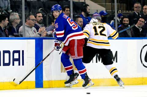 NEW YORK, NEW YORK – FEBRUARY 15: Ryan Lindgren #55 of the New York Rangers and Craig Smith #12 of the Boston Bruins battle along the boards at Madison Square Garden on February 15, 2022, in New York City. (Photo by Steven Ryan/Getty Images)