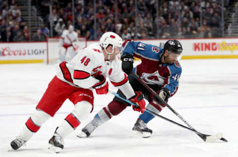 DENVER, COLORADO – DECEMBER 19: Jordan Martinook #48 of the Carolina Hurricanes fights for the puck against Pierre-Edouard Bellemare #41 of the Colorado Avalanche in the first period at the Pepsi Center on December 19, 2019, in Denver, Colorado. (Photo by Matthew Stockman/Getty Images)