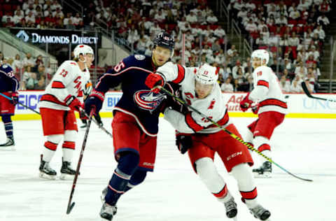 RALEIGH, NC – OCTOBER 12: Warren Foegele #13 of the Carolina Hurricanes skates for a loose puck and gets tangled up with Markus Nutivaara #65 of the Columbus Blue Jackets during an NHL game on October 12, 2019 at PNC Arena in Raleigh North Carolina. (Photo by Gregg Forwerck/NHLI via Getty Images)