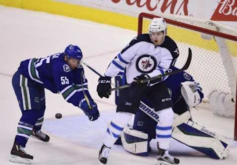 Mar 14, 2016; Vancouver, British Columbia, CAN; Vancouver Canucks defenseman Alex Biega (55) defends Vancouver Canucks goaltender Jacob Markstrom (25) during the third period at Rogers Arena. The Jets won 5-2. Mandatory Credit: Anne-Marie Sorvin-USA TODAY Sports