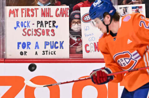 MONTREAL, QC – MARCH 26: A young spectator watches Cole Caufield #22 of the Montreal Canadiens juggle the puck during warmups prior to the game against the Toronto Maple Leafs at Centre Bell on March 26, 2022 in Montreal, Canada. The Montreal Canadiens defeated the Toronto Maple Leafs 4-2. (Photo by Minas Panagiotakis/Getty Images)