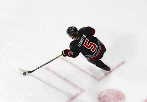 Jan 24, 2016; Raleigh, NC, USA; Carolina Hurricanes defensemen Noah Hanifin (5) skates with the puck against the Calgary Flames at PNC Arena. The Hurricanes defeated the Flames 5-2. Mandatory Credit: James Guillory-USA TODAY Sports