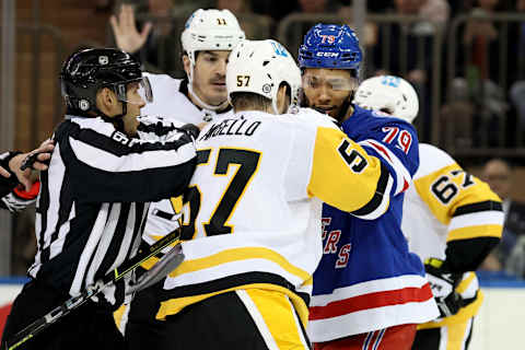 Apr 7, 2022; New York, New York, USA; Pittsburgh Penguins right wing Anthony Angello (57) and New York Rangers defenseman K’Andre Miller (79) are separated by linesman Kory Nagy (97) during the third period at Madison Square Garden. Mandatory Credit: Brad Penner-USA TODAY Sports