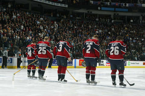 Vancouver Canucks stand at center ice for the National Anthems. (Photo by Jeff Vinnick/Getty Images/NHL)