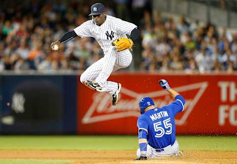 NEW YORK, NY – AUGUST 07: Didi Gregorius #18 of the New York Yankees leaps over Russell Martin #55 of the Toronto Blue Jays after touching second base for a force out to end the fourth inning at Yankee Stadium on August 7, 2015 in the Bronx borough of New York City. (Photo by Jim McIsaac/Getty Images)