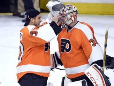 Dec 17, 2015; Philadelphia, PA, USA; Philadelphia Flyers goalie Michal Neuvirth (30) and goalie Steve Mason (35) celebrate after win Vancouver Canucks at Wells Fargo Center. The Flyers defeated the Canucks, 2-0. Mandatory Credit: Eric Hartline-USA TODAY Sports