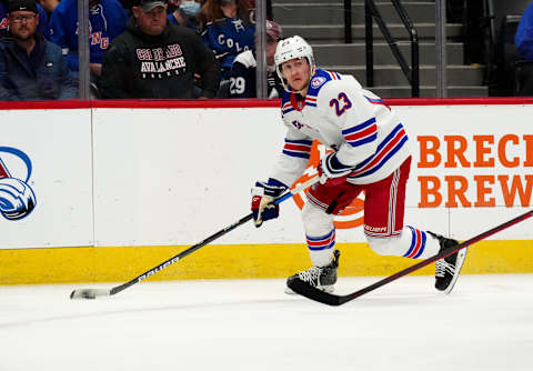 Dec 14, 2021; Denver, Colorado, USA; New York Rangers defenseman Adam Fox (23) controls the puck in the first period against the Colorado Avalanche at Ball Arena. Mandatory Credit: Ron Chenoy-USA TODAY Sports