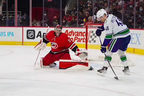 Jan 15, 2022; Raleigh, North Carolina, USA; Vancouver Canucks center Elias Pettersson (40) holds onto the puck in front of Carolina Hurricanes goaltender Frederik Andersen (31) during the second period at PNC Arena. Mandatory Credit: James Guillory-USA TODAY Sports