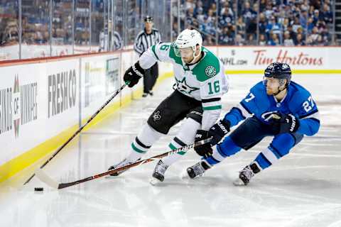 WINNIPEG, MB – MARCH 25: Jason Dickinson #16 of the Dallas Stars and Nikolaj Ehlers #27 of the Winnipeg Jets battle for the puck along the boards during third period action at the Bell MTS Place on March 25, 2019 in Winnipeg, Manitoba, Canada. (Photo by Darcy Finley/NHLI via Getty Images)