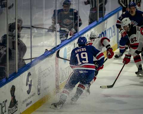 Chase De Leo (7) and Nikita Okhotiuk (82) play keep away with the puck against Rochester Americans player Peyton Krebs (19) during the 2022 Calder Cup Playoffs on Thursday, May 19, 2022 at the Adirondack Bank Center in Utica.De Leo Okhotiuk Krebs Utica Comets Vs Rochester Americans