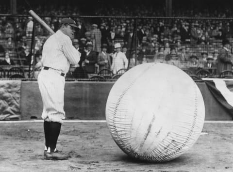 April 1927: Baseball player Babe Ruth (George Herman Ruth, 1895 – 1948) taking a swipe at an enormous ball. (Photo by Fox Photos/Getty Images)