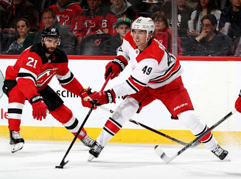 NEWARK, NJ – FEBRUARY 15: Victor Rask #49 of the Carolina Hurricanes passes the puck as Kyle Palmieri #21 of the New Jersey Devils defends on February 15, 2018 at Prudential Center in Newark, New Jersey. (Photo by Elsa/Getty Images)