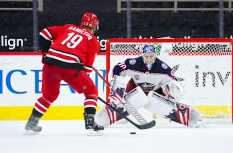 Mar 20, 2021; Raleigh, North Carolina, USA; Columbus Blue Jackets goaltender Elvis Merzlikins (90) waits for Carolina Hurricanes defenseman Dougie Hamilton (19) shot attempt in the overtime at PNC Arena. Mandatory Credit: James Guillory-USA TODAY Sports