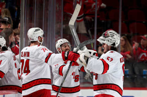 NEWARK, NEW JERSEY – APRIL 23: Jaccob Slavin #72 and Vincent Trocheck #16 of the Carolina Hurricanes celebrate the win with Pyotr Kochetkov #52 after the game against the New Jersey Devils at Prudential Center on April 23, 2022 in Newark, New Jersey. The Carolina Hurricanes defeated the New Jersey Devils 3-2 in overtime. Kochetkov made his NHL debut in today’s game. (Photo by Elsa/Getty Images)