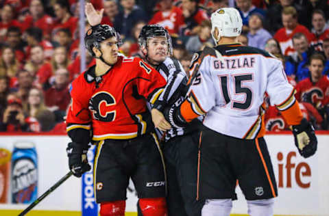 Dec 29, 2016; Calgary, Alberta, CAN; Calgary Flames center Mikael Backlund (11) and Anaheim Ducks center Ryan Getzlaf (15) are separated by linesman David Brisebois (96) during the third period at Scotiabank Saddledome. Anaheim Ducks won 3-1. Mandatory Credit: Sergei Belski-USA TODAY Sports