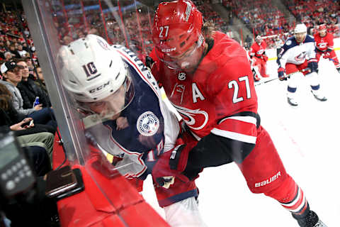 RALEIGH, NC – DECEMBER 16: Justin Faulk #27 of the Carolina Hurricanes battles along the boards with Alexander Wennberg #10 of the Columbus Blue Jackets during an NHL game on December 16, 2017 at PNC Arena in Raleigh, North Carolina. (Photo by Gregg Forwerck/NHLI via Getty Images)