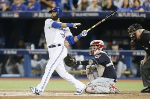 Oct 17, 2016; Toronto, Ontario, CAN; Toronto Blue Jays right fielder Jose Bautista (left) hits a single against Cleveland Indians catcher Roberto Perez (right) during the third inning in game three of the 2016 ALCS playoff baseball series at Rogers Centre. Mandatory Credit: John E. Sokolowski-USA TODAY Sports