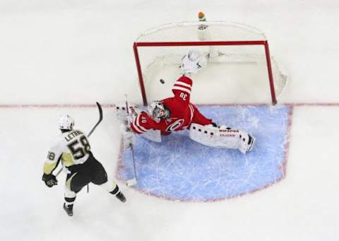 Feb 12, 2016; Raleigh, NC, USA; Pittsburgh Penguins defensemen Kris Letang (58) scores the game winning goal during the shoot out against Carolina Hurricanes goalie Cam Ward (30) at PNC Arena. The Pittsburgh Penguins defeated the Carolina Hurricanes 2-1 in the shoot out. Mandatory Credit: James Guillory-USA TODAY Sports