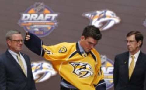 Jun 24, 2016; Buffalo, NY, USA; Dante Fabbro puts on a team jersey after being selected as the number seventeen overall draft pick by the Nashville Predators in the first round of the 2016 NHL Draft at the First Niagra Center. Mandatory Credit: Timothy T. Ludwig-USA TODAY Sports