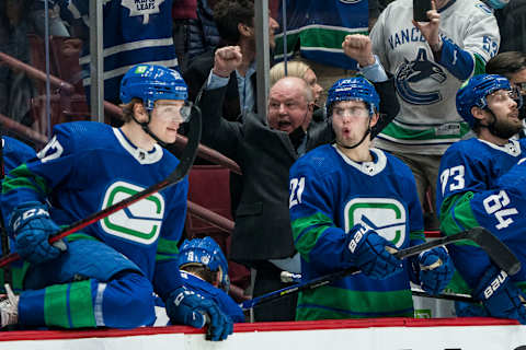 Dec 14, 2021; Vancouver, British Columbia, CAN; Vancouver Canucks forward Vasily Podkolzin (92) and forward Nils Hoglander (21) and head coach Bruce Boudreau celebrate their victory against the Columbus Blue Jackets in the third period at Rogers Arena. Vancouver Won 4-3. Mandatory Credit: Bob Frid-USA TODAY Sports