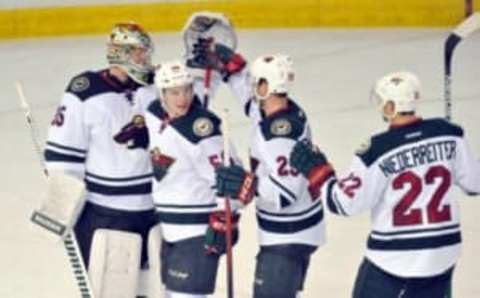 Feb 18, 2016; Edmonton, Alberta, CAN; Minnesota Wild goalie Niklas Backstrom (32) celebrates their win with Wild center Erik Haula (56) and Wild right winger Jason Pominville (29) and Wild right winger Nino Niederreiter (22) against the Edmonton Oilers at the end of the third period at Rexall Place. Minnesota Wild won the game 5-2. Mandatory Credit: Walter Tychnowicz-USA TODAY Sports