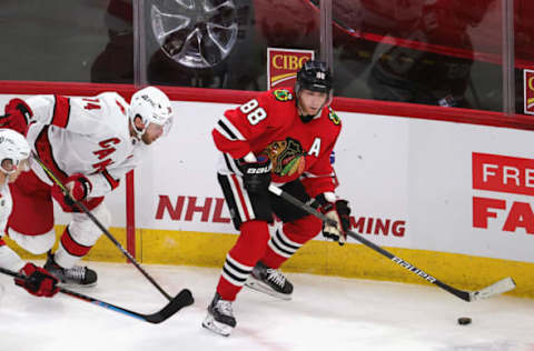 CHICAGO, ILLINOIS – MARCH 30: Patrick Kane #88 of the Chicago Blackhawks looks to pass under pressure from Jaccob Slavin #74 of the Carolina Hurricanes at the United Center on March 30, 2021, in Chicago, Illinois. The Blackhawks defeated the Hurricanes 2-1. (Photo by Jonathan Daniel/Getty Images)