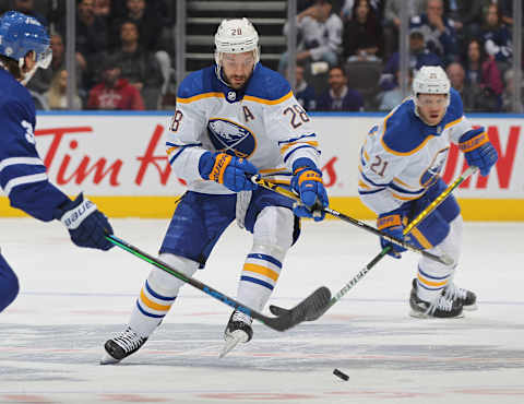 TORONTO, ON – APRIL 12: Zemgus Girgensons #28 of the Buffalo Sabres tries to handle a bouncing puck against the Toronto Maple Leafs during an NHL game at Scotiabank Arena on April 12, 2022 in Toronto, Ontario, Canada. The Sabres defeated the Maple Leafs 5-2. (Photo by Claus Andersen/Getty Images)