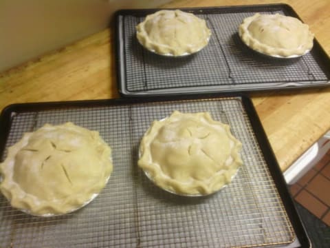 Several pies on baking racks.