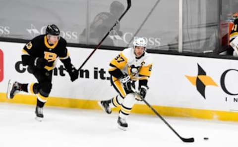 Jan 26, 2021; Boston, Massachusetts, USA; Pittsburgh Penguins center Sidney Crosby (87) skates with the puck in front of Boston Bruins center Charlie Coyle (13) during the second period at the TD Garden. Mandatory Credit: Brian Fluharty-USA TODAY Sports