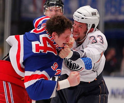 2002: Steve MacIntyre #33 of the Edmonton Oilers fights with Derek Boogaard #94 of the New York Rangers. (Photo by Paul Bereswill/Getty Images)