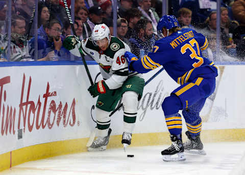 Nov 10, 2023; Buffalo, New York, USA; Minnesota Wild defenseman Jared Spurgeon (46) and Buffalo Sabres center Casey Mittelstadt (37) go after a loose puck along the boards during the second period at KeyBank Center. Mandatory Credit: Timothy T. Ludwig-USA TODAY Sports