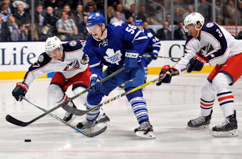 TORONTO, ON – APRIL 6: Byron Froese #56 of the Toronto Maple Leafs controls the puck past Ryan Murray #27 and Seth Jones #3 of the Columbus Blue Jackets during game action on April 6, 2016 at Air Canada Centre in Toronto, Ontario, Canada. (Photo by Graig Abel/NHLI via Getty Images)