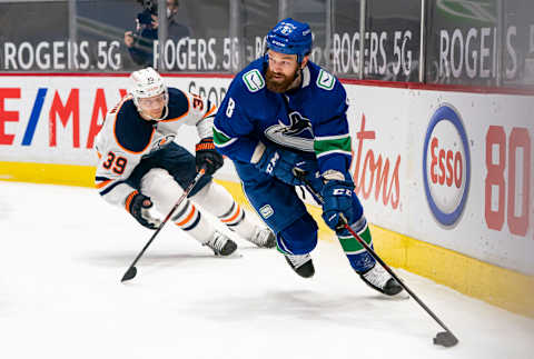 VANCOUVER, BC – MARCH 13: Jordie Benn #8 of the Vancouver Canucks tries to break free from Alex Chiasson #39 of the Edmonton Oilers during NHL action at Rogers Arena on March 13, 2021 in Vancouver, Canada. (Photo by Rich Lam/Getty Images)