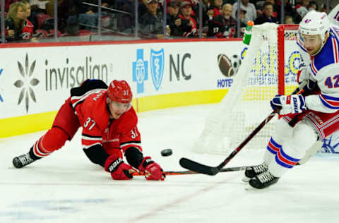 RALEIGH, NC – NOVEMBER 7: Andrei Svechnikov #37 of the Carolina Hurricanes and Brendan Smith #42 of the New York Rangers battle for the loose puck during an NHL game on November 7, 2019 at PNC Arena in Raleigh, North Carolina. (Photo by Gregg Forwerck/NHLI via Getty Images)