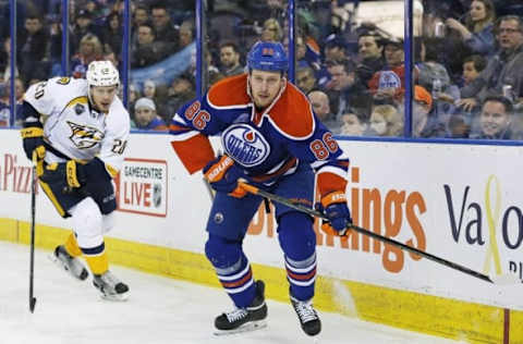 Mar 14, 2016; Edmonton, Alberta, CAN; Edmonton Oilers defensemen Nikita Nikitin (86) plays the puck while being chased by Nashville Predators forward Miikka Salomaki (20) during the third period at Rexall Place. Mandatory Credit: Perry Nelson-USA TODAY Sports