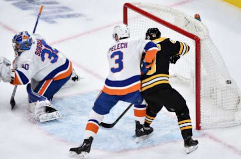 May 29, 2021; Boston, MA, USA; Boston Bruins right wing David Pastrnak (88) (not pictured) scores a goal past New York Islanders goaltender Ilya Sorokin (30) while defenseman Adam Pelech (3) and center Brad Marchand (63) battle in the crease during the second period in game one of the second round of the 2021 Stanley Cup Playoffs at TD Garden. Mandatory Credit: Bob DeChiara-USA TODAY Sports