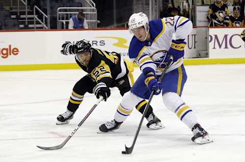 Oct 5, 2021; Pittsburgh, Pennsylvania, USA; Pittsburgh Penguins defenseman Mark Friedman (52) tries to strip the puck from Buffalo Sabres right wing Jack Quinn (22) during the third period at PPG Paints Arena. The Penguins won 5-4 in a shootout. Mandatory Credit: Charles LeClaire-USA TODAY Sports