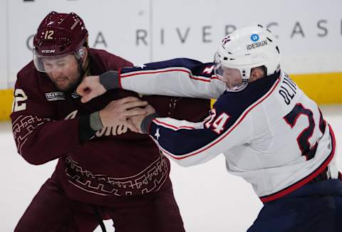 Feb 19, 2023; Tempe, Arizona, USA; Arizona Coyotes left wing Nick Ritchie (12) and Columbus Blue Jackets right wing Mathieu Olivier (24) fight during the third period at Mullett Arena. Mandatory Credit: Joe Camporeale-USA TODAY Sports