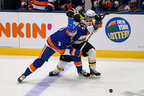 Jan 18, 2021; Uniondale, New York, USA; New York Islanders defenseman Adam Pelech (3) and Boston Bruins center Brad Marchand (63) battle for the puck during the third period at Nassau Veterans Memorial Coliseum. Mandatory Credit: Dennis Schneidler-USA TODAY Sports