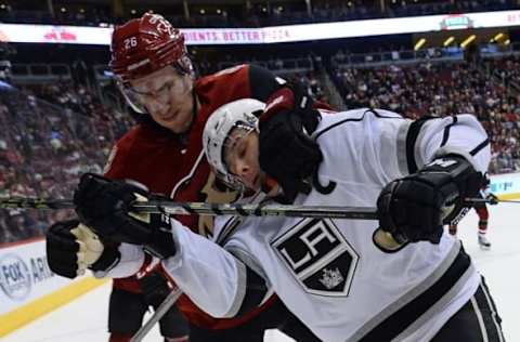 Feb 2, 2016; Glendale, AZ, USA; Arizona Coyotes defenseman Michael Stone (26) checks Los Angeles Kings right wing Dustin Brown (23) during the third period at Gila River Arena. The Kings won 6-2. Mandatory Credit: Joe Camporeale-USA TODAY Sports