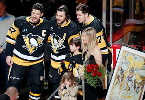 Apr 2, 2023; Pittsburgh, Pennsylvania, USA; Pittsburgh Penguins center Sidney Crosby (87) and center Evgeni Malkin (71) pose with defenseman Kris Letang (58) and the Letang family as Letang is honored before playing in his 1000th career NHL game against the Philadelphia Flyers at PPG Paints Arena. Mandatory Credit: Charles LeClaire-USA TODAY Sports