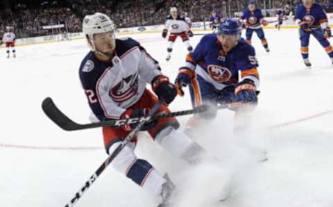 NEW YORK, NEW YORK – NOVEMBER 30: Emil Bemstrom #52 of the Columbus Blue Jackets shoots the puck away from Johnny Boychuk #55 of the New York Islanders during the first period at the Barclays Center on November 30, 2019 in the Brooklyn borough of New York City. (Photo by Bruce Bennett/Getty Images)