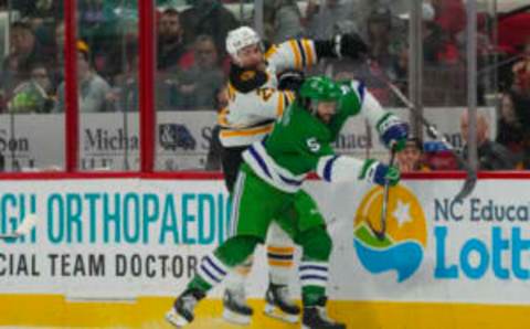 Mar 26, 2023; Raleigh, North Carolina, USA; Carolina Hurricanes defenseman Jalen Chatfield (5) checks Boston Bruins right wing Garnet Hathaway (21) during the second period at PNC Arena. Mandatory Credit: James Guillory-USA TODAY Sports