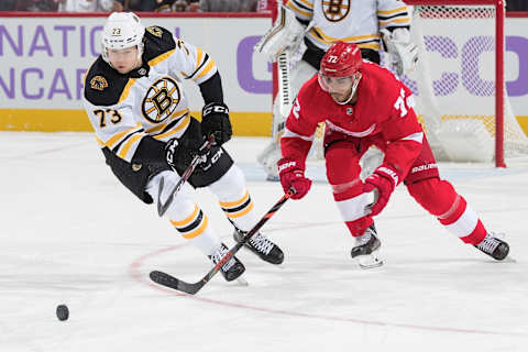 DETROIT, MI – NOVEMBER 08: Charlie McAvoy #73 of the Boston Bruins battles up ice for the puck with Andreas Athanasiou #72 of the Detroit Red Wings during an NHL game at Little Caesars Arena on November 8, 2019 in Detroit, Michigan. (Photo by Dave Reginek/NHLI via Getty Images)