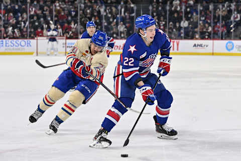 LAVAL, QC – APRIL 08: Jack Quinn #22 of the Rochester Americans skates the puck against Gabriel Bourque #20 of the Laval Rocket during the first period at Place Bell on April 8, 2022 in Laval, Canada. (Photo by Minas Panagiotakis/Getty Images)